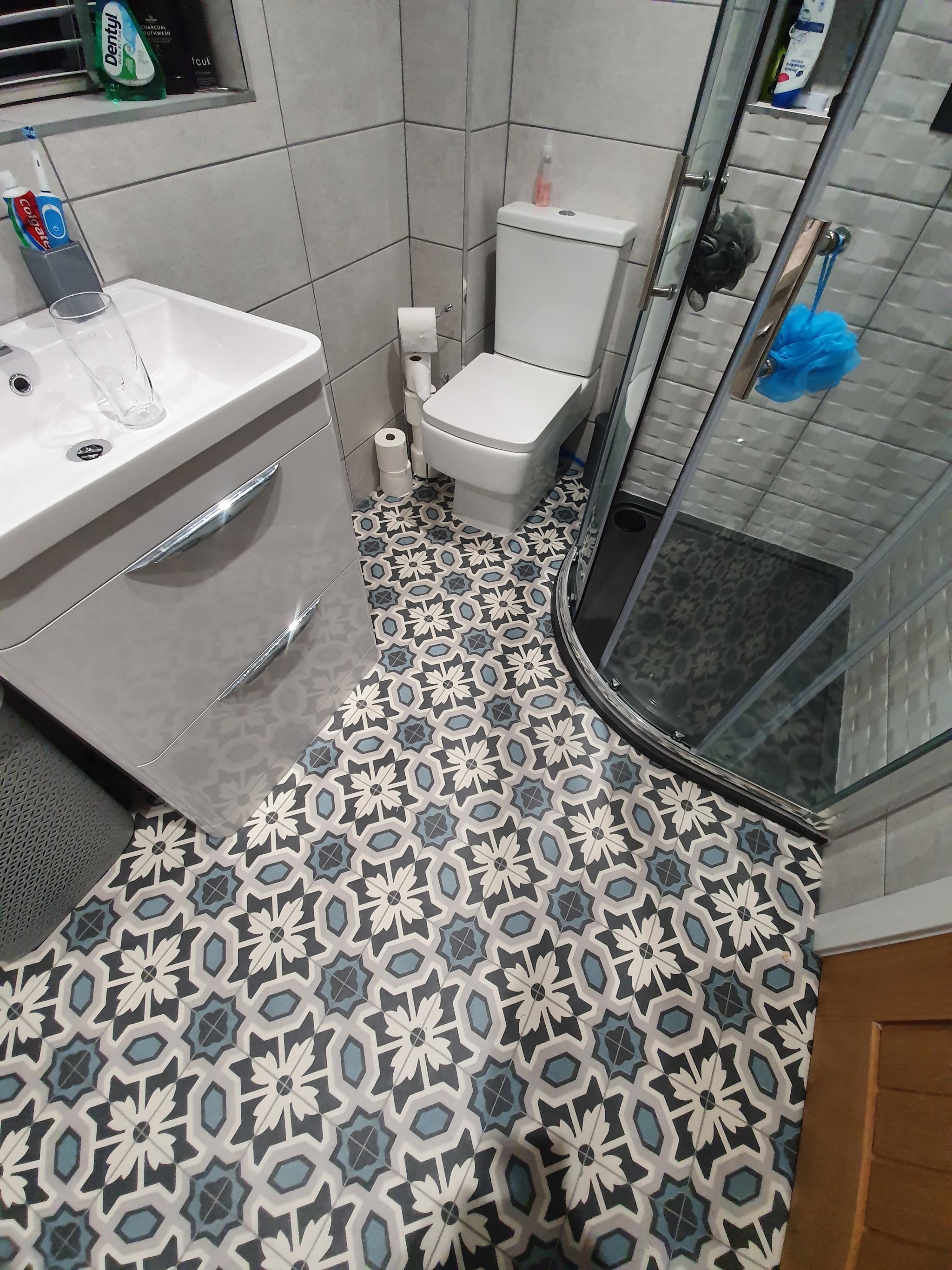 Blue and white patterned floor around a shower and basin