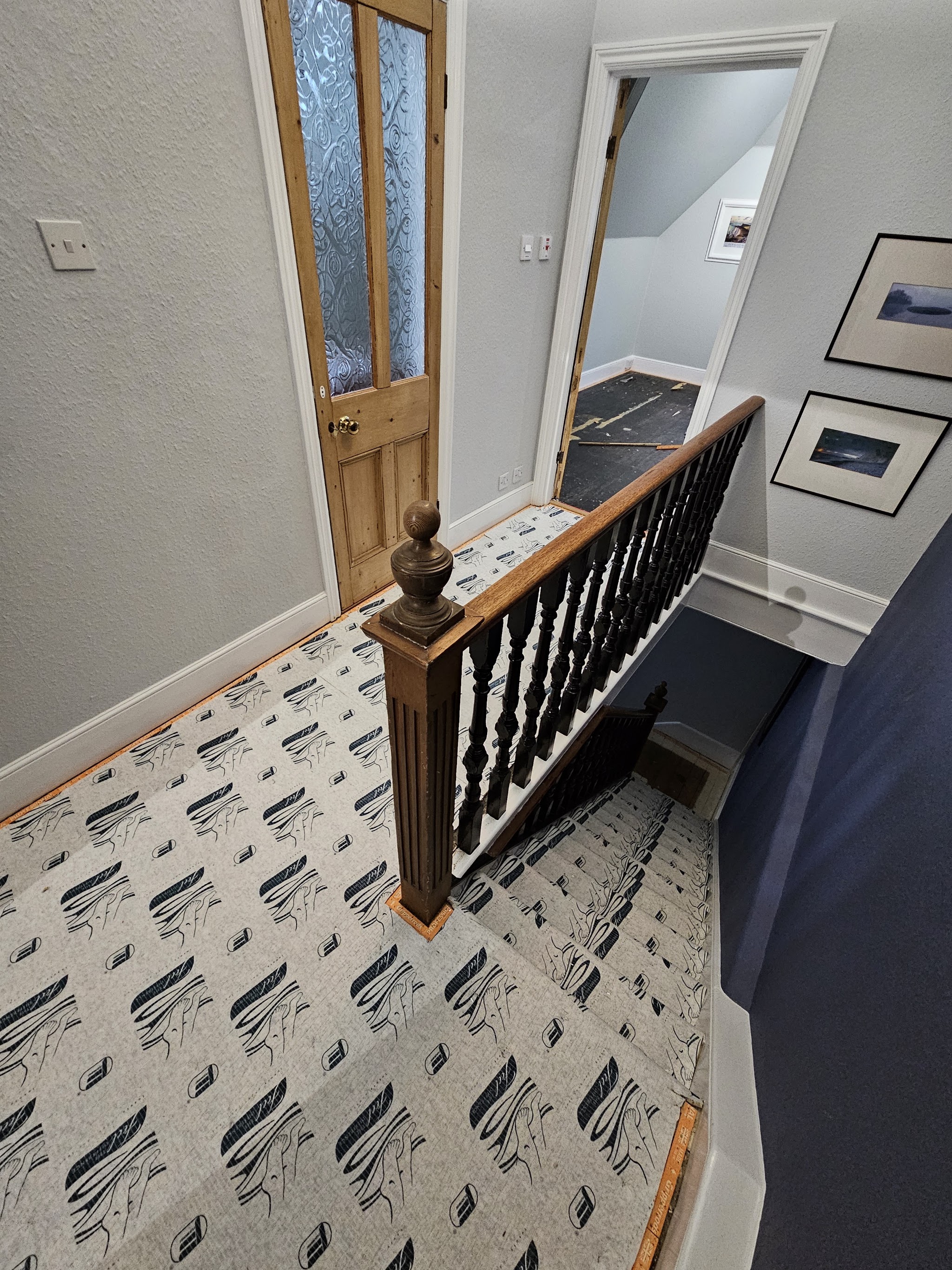 Patterned carpet on stairs and landing with a dark wood banister