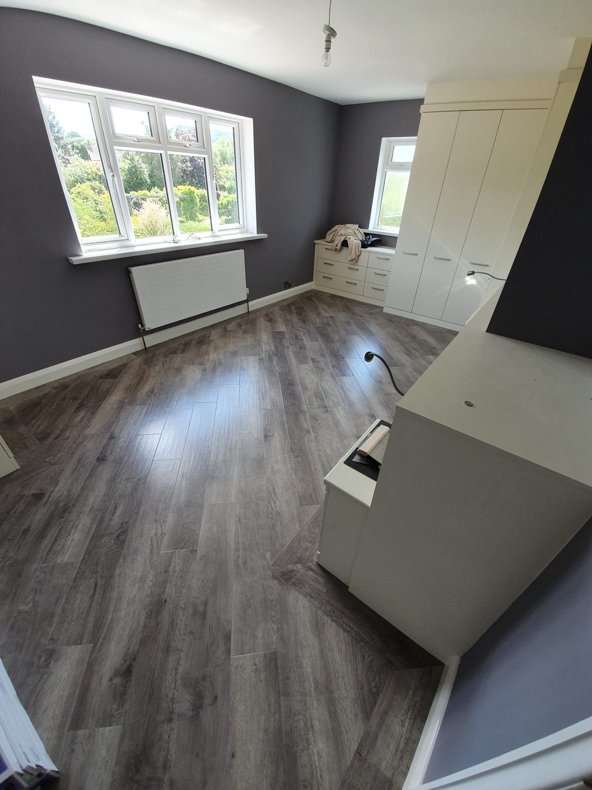The same bedroom with a grey wood-effect plank floor fitted