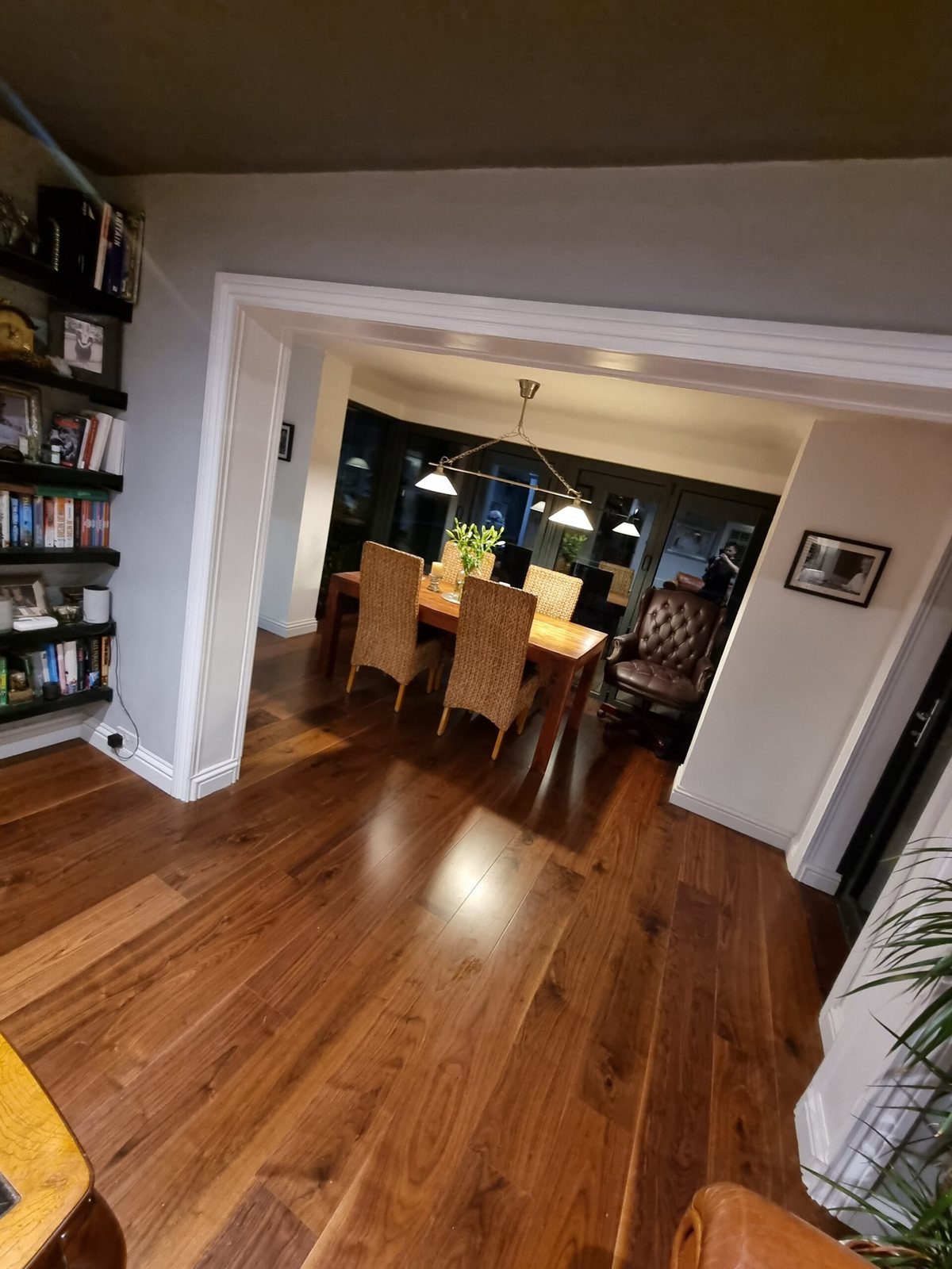 Dark wood-effect floor through to a dining room