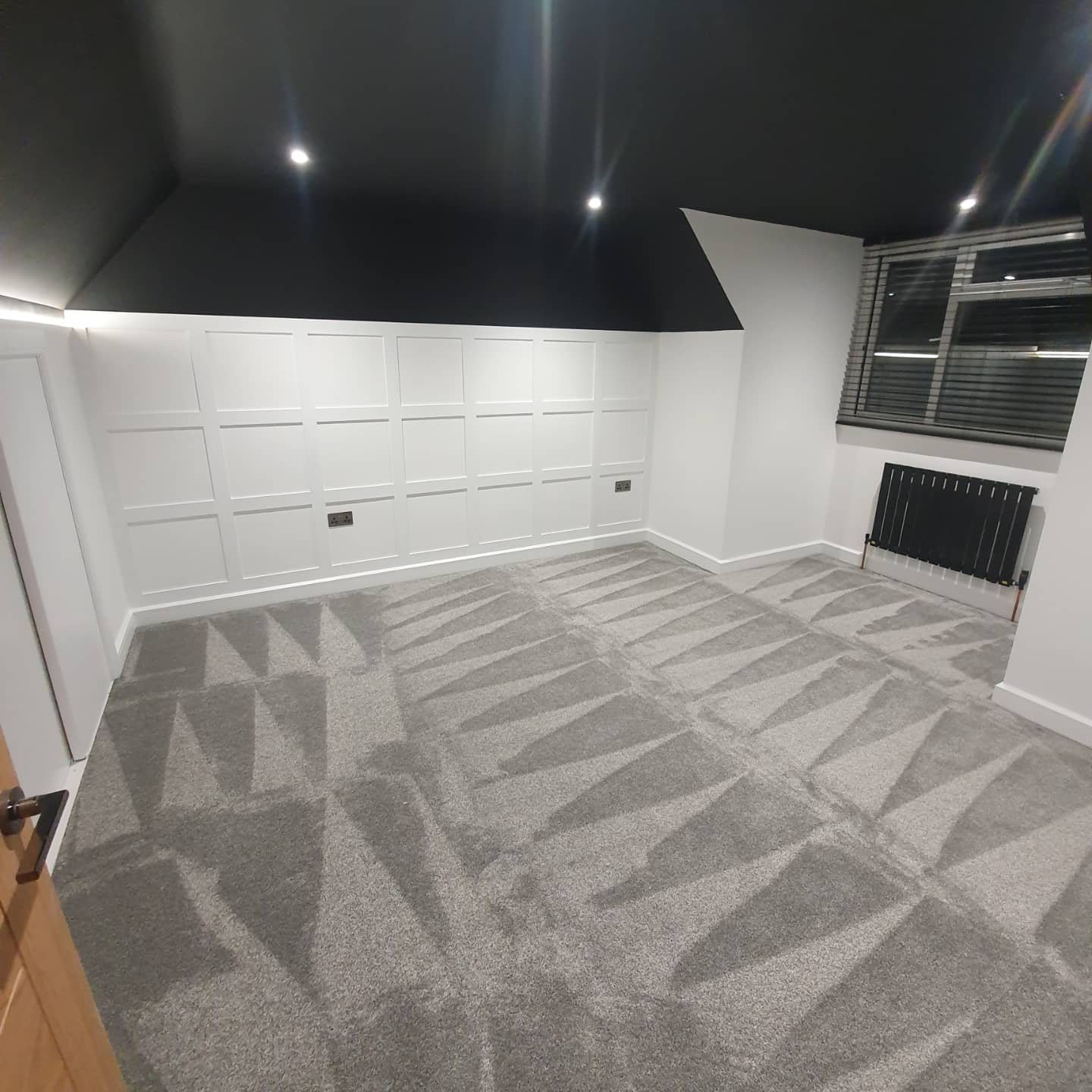 Grey geometric patterned carpet in a panelled room