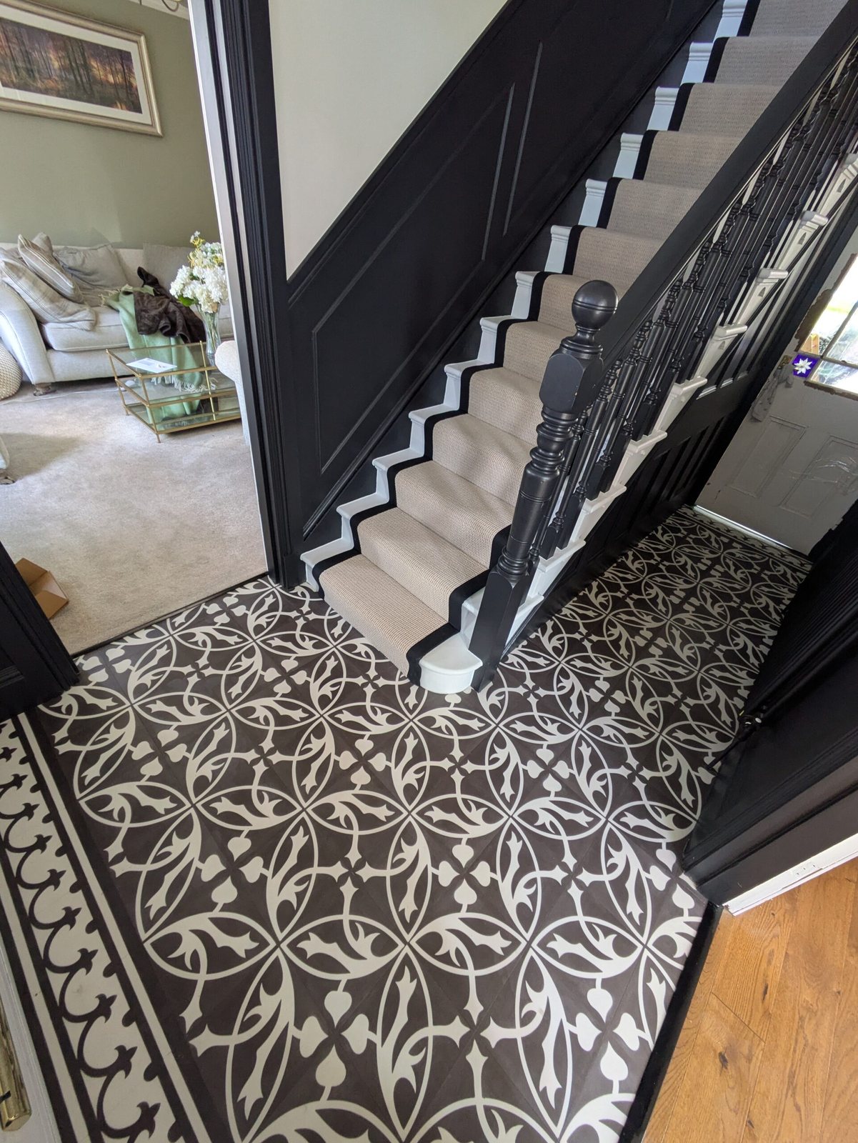 Black and white patterned hall floor with a stair runner